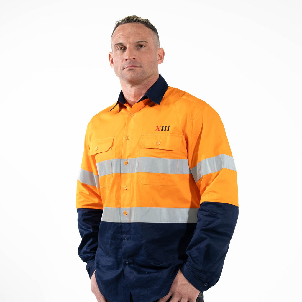Person wearing an orange and navy high-visibility work shirt on a white background