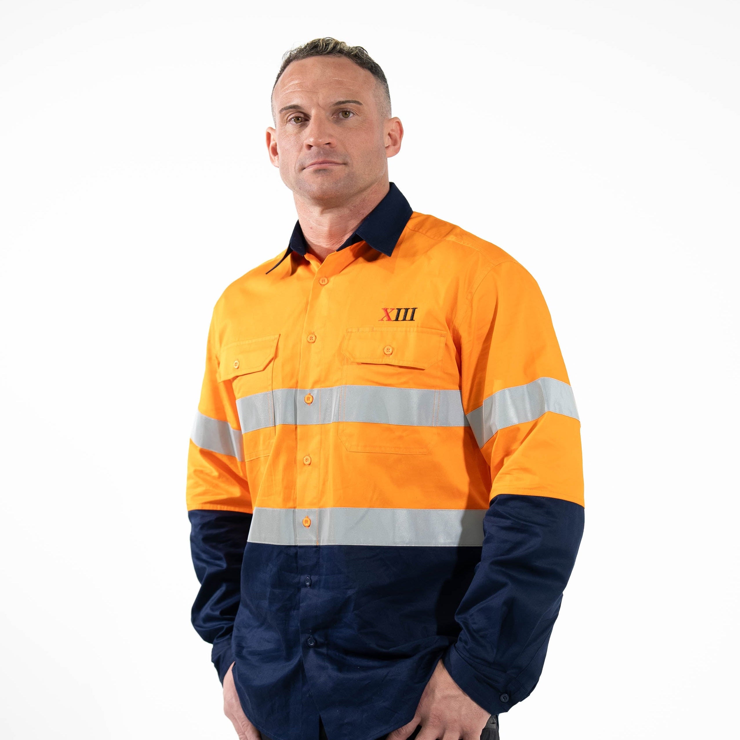 Person wearing an orange and navy high-visibility work shirt on a white background