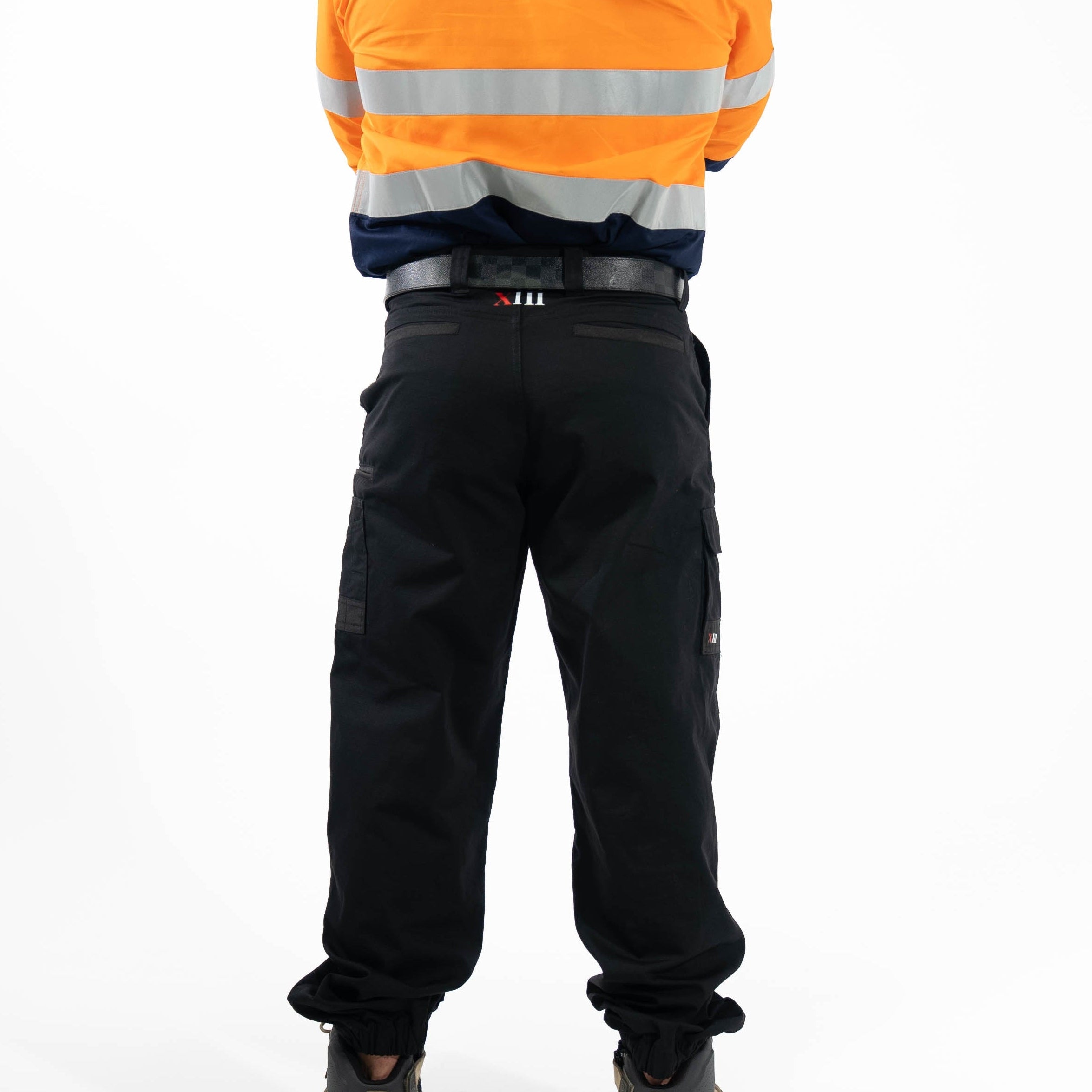 Person wearing an orange high-visibility jacket and black pants on a white background